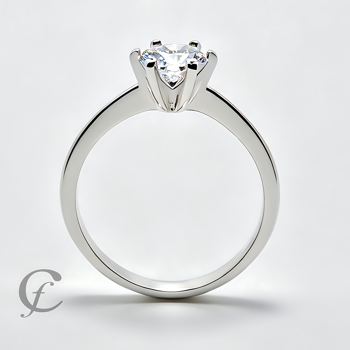 A silver solitaire engagement ring with a heart-shaped clear gemstone in a four-prong setting, shown on a light gray background.