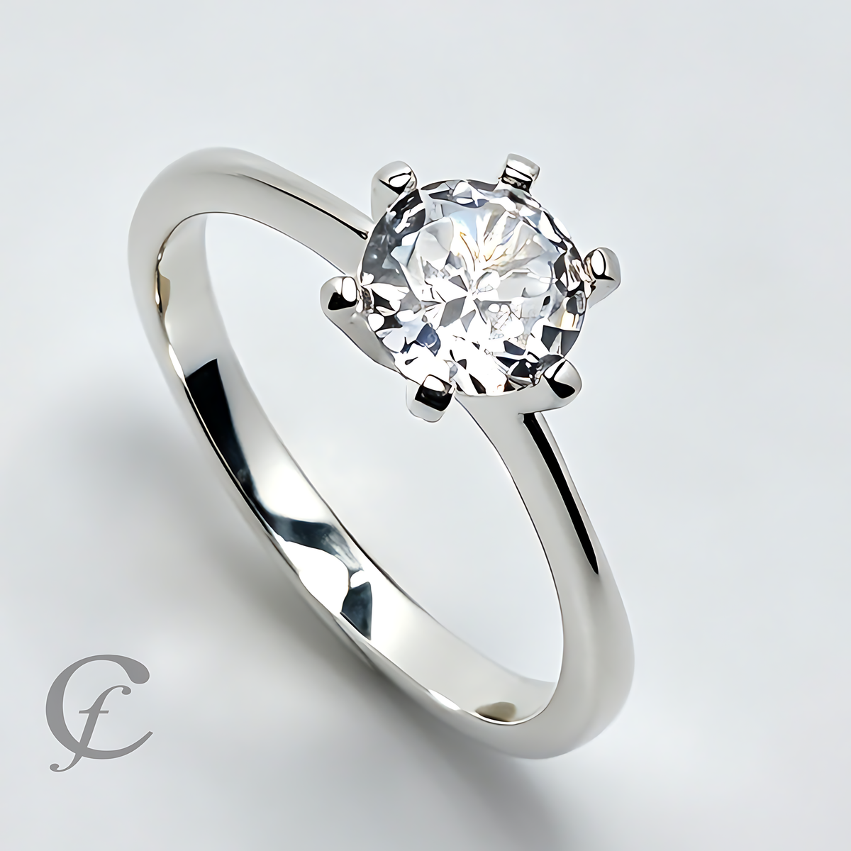 A classic solitaire engagement ring featuring a round brilliant-cut clear gemstone in a six-prong setting on a polished silver-colored band, shown on a light gray background .