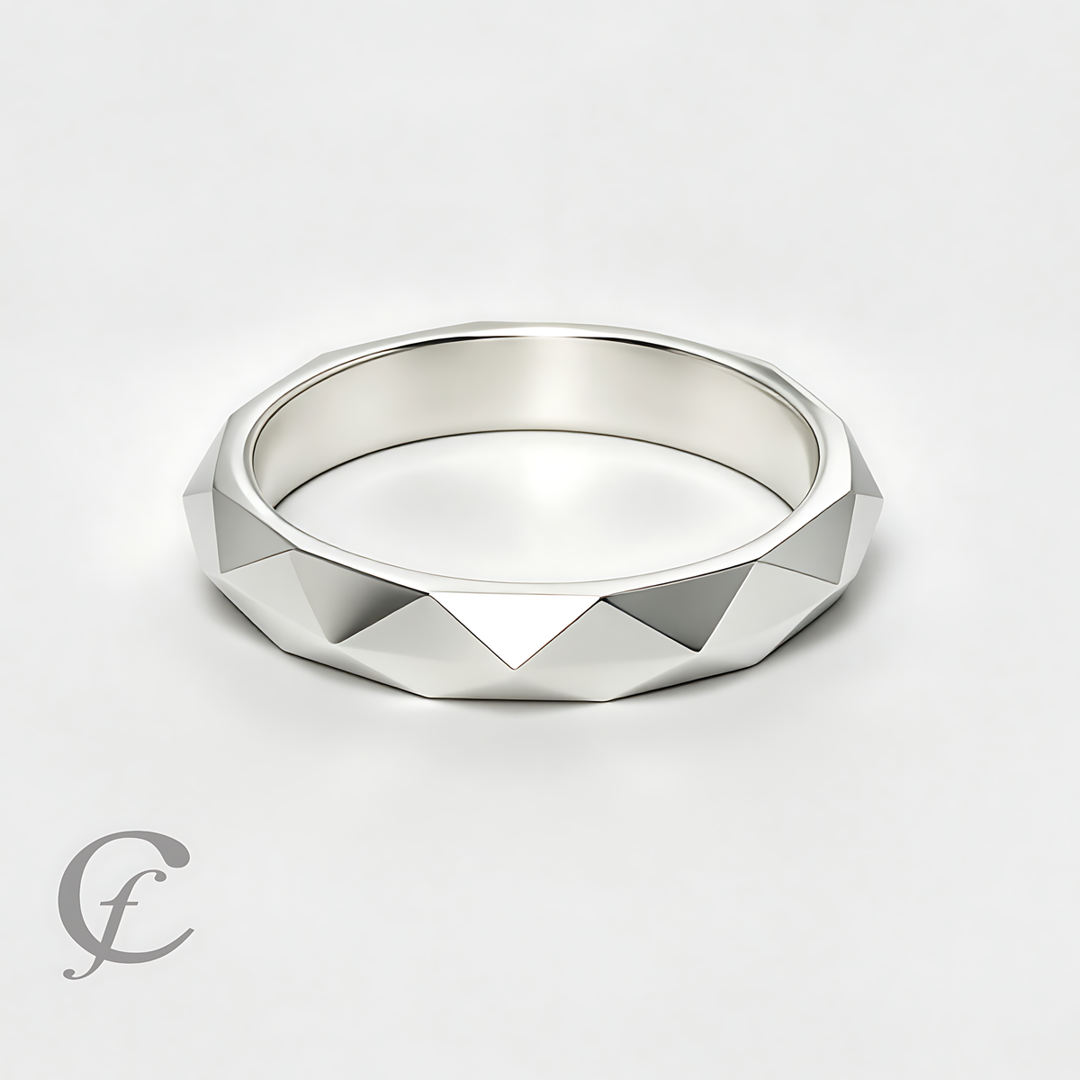 A silver geometric ring with a faceted triangular pattern, photographed on a clean white background with a subtle shadow.