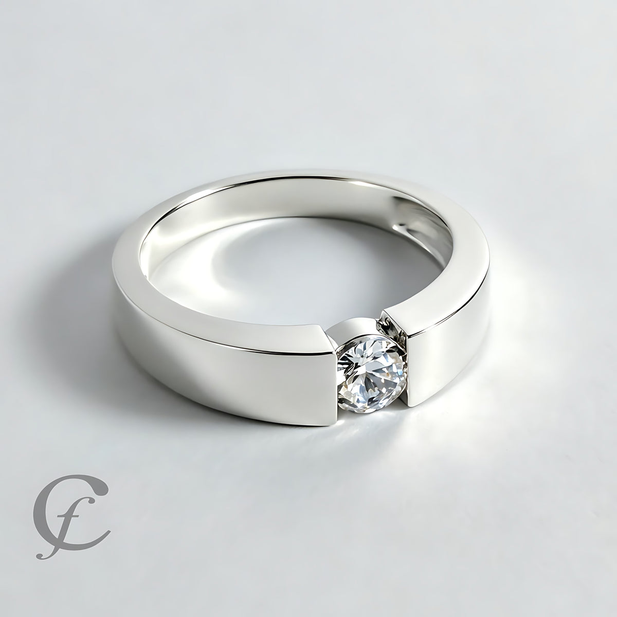 A polished silver band ring with a single round clear gemstone in a prong setting, photographed on a light gray background.