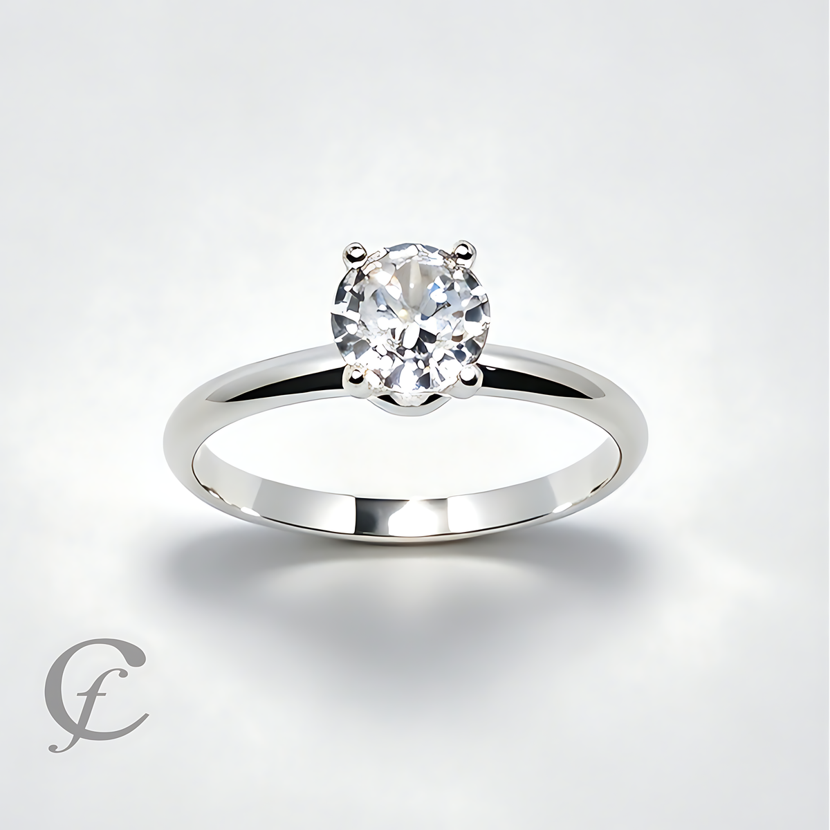 A classic solitaire engagement ring featuring a round brilliant-cut diamond set in a polished silver-colored band, shown on a light gray background with a subtle shadow.